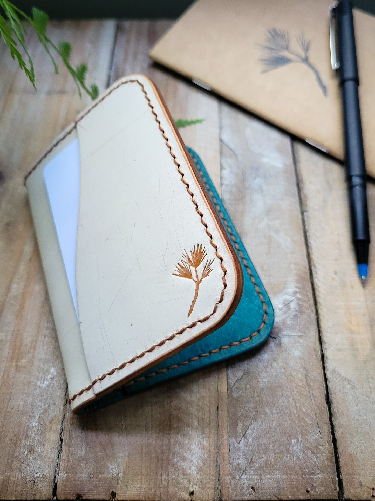 Leather wallet with floral embroidery on a wooden surface