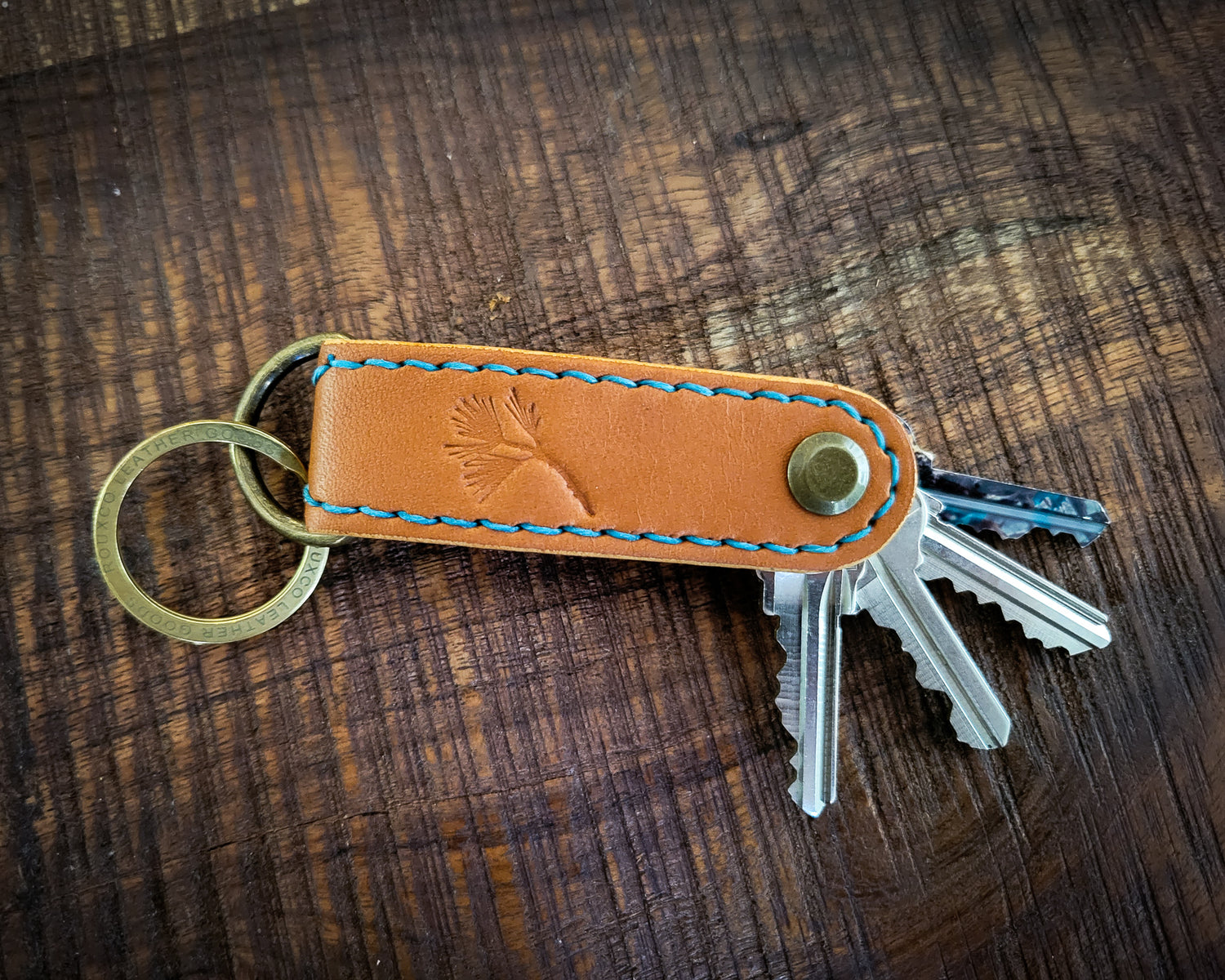 Tan Leather EDC Key Organizer stitched with turquoise thread holding 4 keys