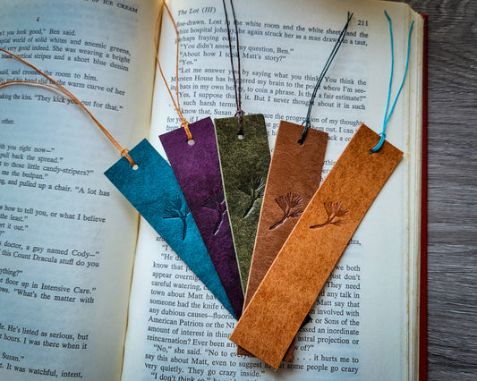 Five Pueblo leather bookmarks in blue, purple, green, brown, and orange laying on an open Salem's Lot book
