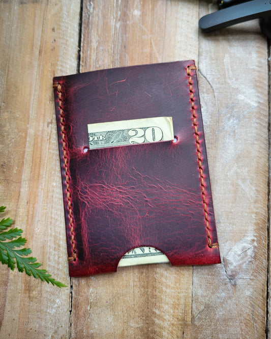 Red leather wallet with money on a wooden surface