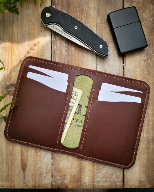 Brown leather wallet with card slots on a wooden surface with a knife and lighter.