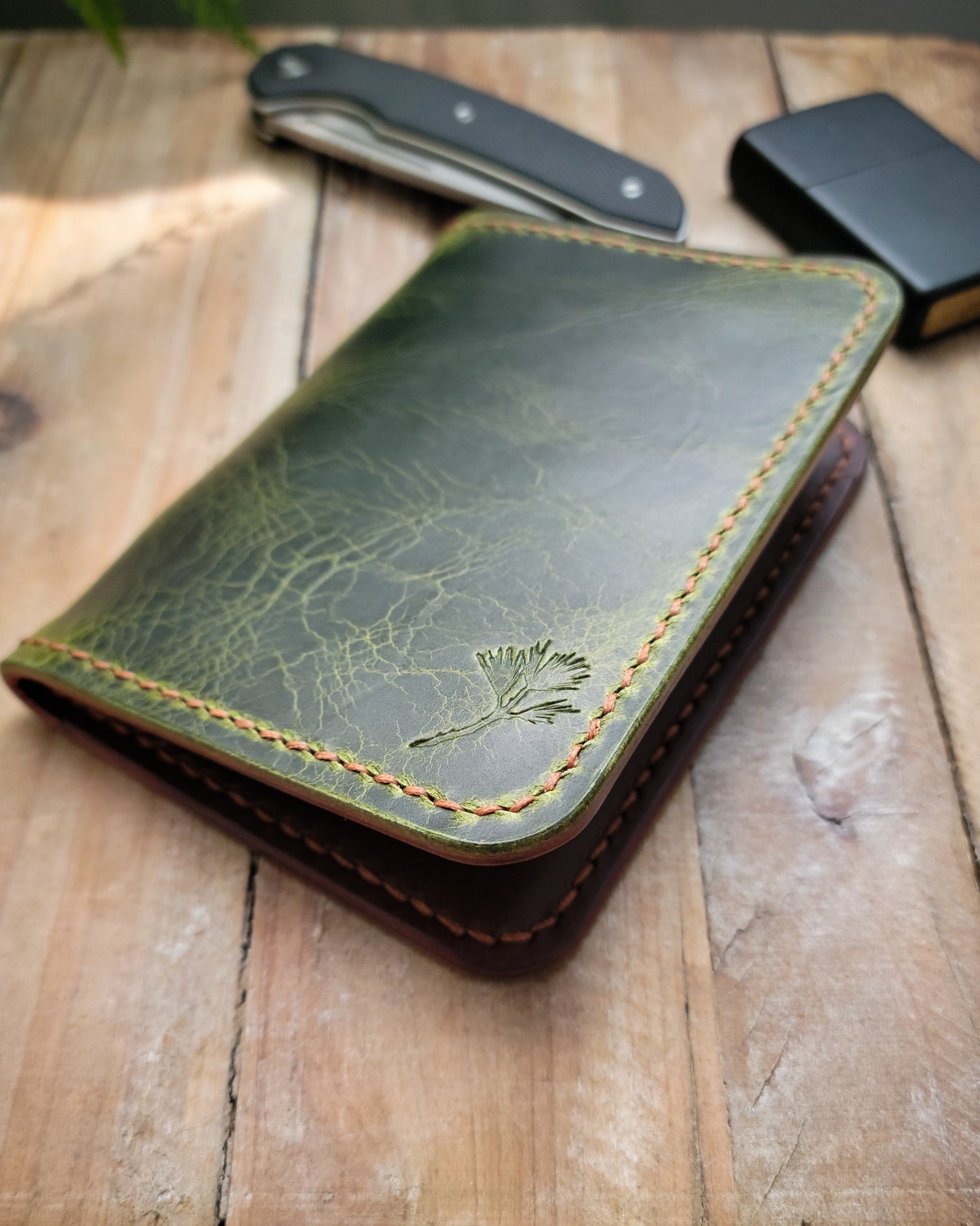 Green leather wallet on a wooden surface