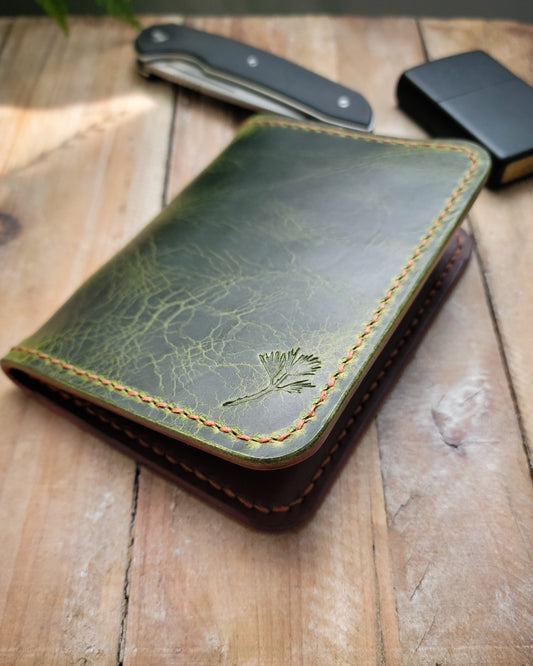 Green leather wallet on a wooden surface