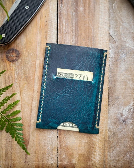 Blue leather wallet with money on a wooden surface