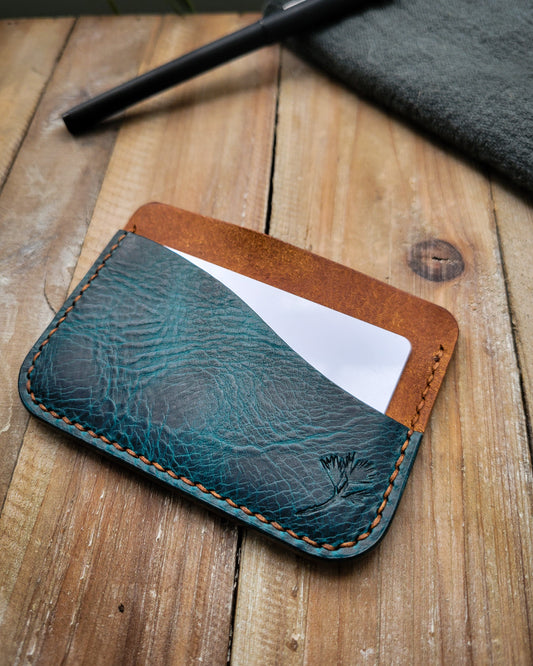 Blue leather cardholder on a wooden surface